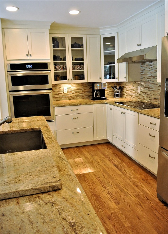 Kitchen - transitional light wood floor kitchen idea in Boston with an undermount sink, shaker cabinets, white cabinets, granite countertops, stainless steel appliances and an island
