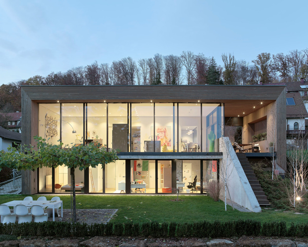 Стильный дизайн: деревянный частный загородный дом в современном стиле с плоской крышей, зеленой крышей и отделкой планкеном - последний тренд