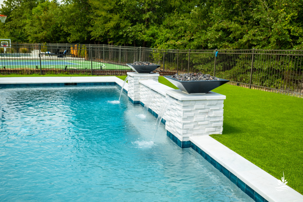Esempio di una grande piscina naturale minimalista rettangolare dietro casa con paesaggistica bordo piscina e pedane