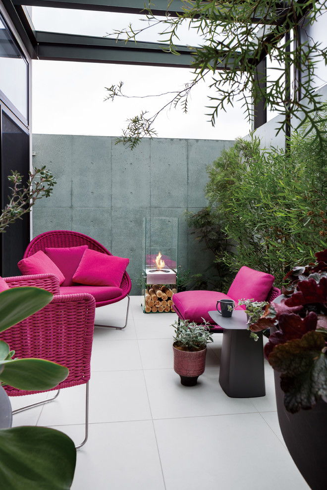 Photo of an eclectic courtyard patio in Tokyo with a fire feature and a roof extension.