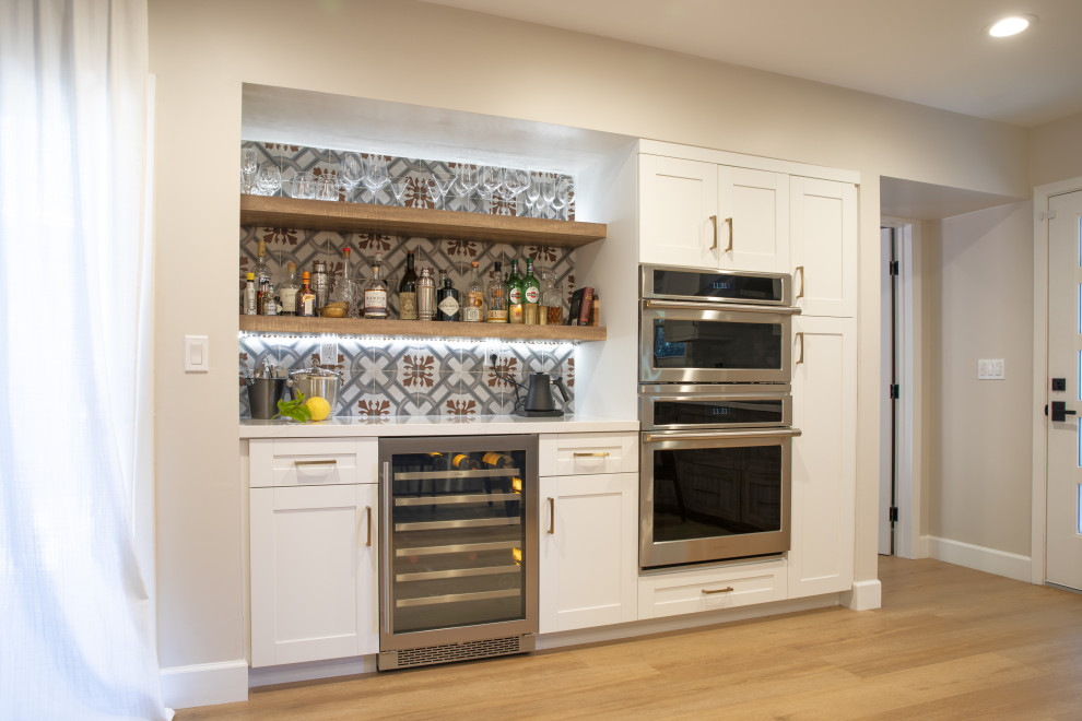 Inspiration for a mid-sized single-wall home bar in San Francisco with shaker cabinets, white cabinets, quartz benchtops, multi-coloured splashback, ceramic splashback and white benchtop.