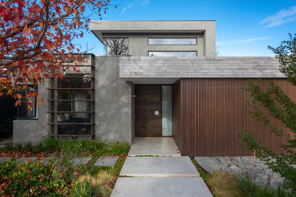 Inspiration for a contemporary two-storey grey house exterior in Melbourne with a flat roof.