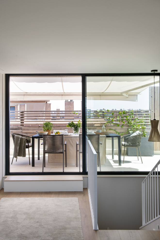 Imagen de terraza actual grande en azotea con toldo y barandilla de madera
