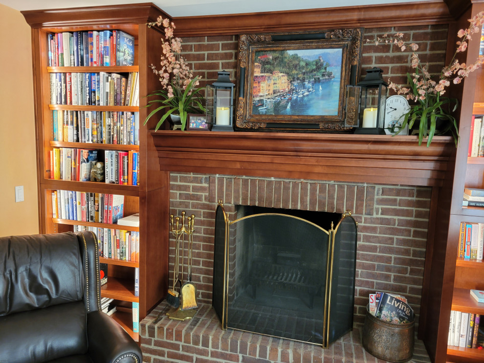 Idée de décoration pour une salle de séjour tradition de taille moyenne et fermée avec une bibliothèque ou un coin lecture, un mur beige, moquette, une cheminée standard, un manteau de cheminée en brique et un sol beige.