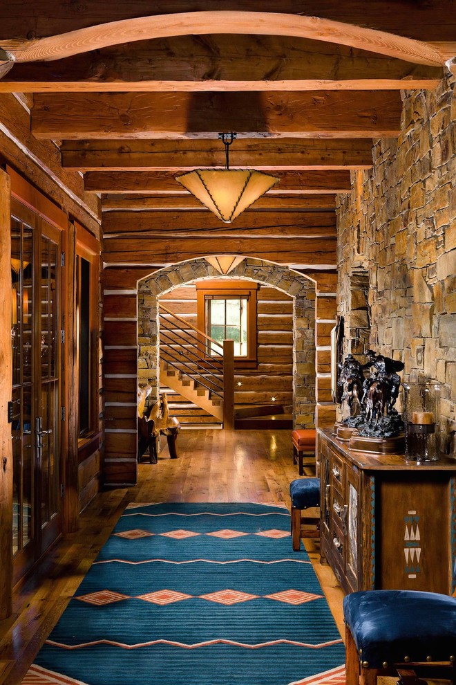 Large mountain style medium tone wood floor and brown floor hallway photo with brown walls