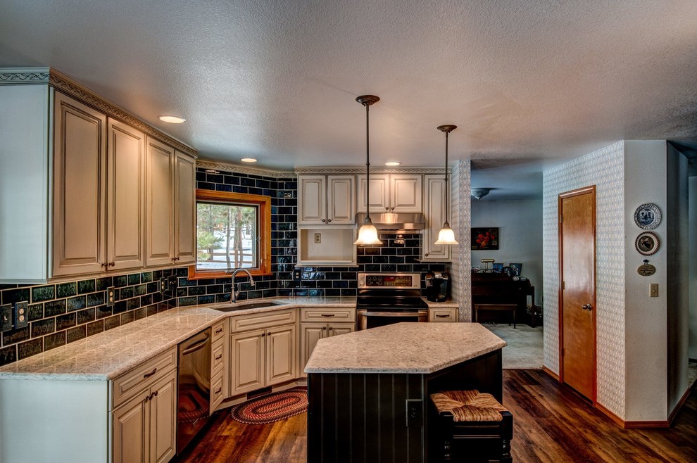 Mid-sized traditional l-shaped eat-in kitchen in Denver with a drop-in sink, raised-panel cabinets, white cabinets, quartz benchtops, blue splashback, ceramic splashback, stainless steel appliances, medium hardwood floors and with island.