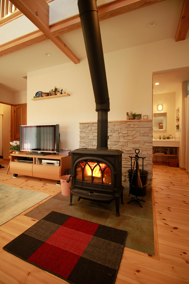 Country living room in Other with white walls, tatami floors, a wood stove and a freestanding tv.