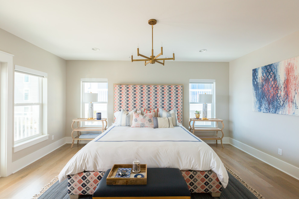 Inspiration for a beach style bedroom in Miami with beige walls, light hardwood floors and brown floor.