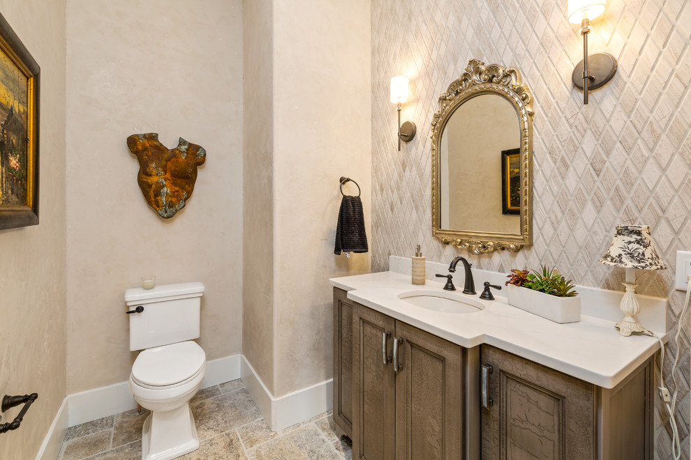 Design ideas for a mid-sized country powder room in Cincinnati with recessed-panel cabinets, white cabinets, a two-piece toilet, white tile, mosaic tile, white walls, ceramic floors, an undermount sink, engineered quartz benchtops, multi-coloured floor and grey benchtops.