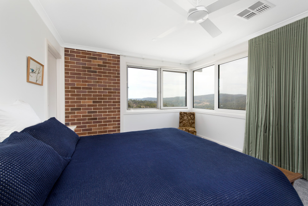 Design ideas for a mid-sized midcentury master bedroom in Canberra - Queanbeyan with white walls, carpet, grey floor and brick walls.