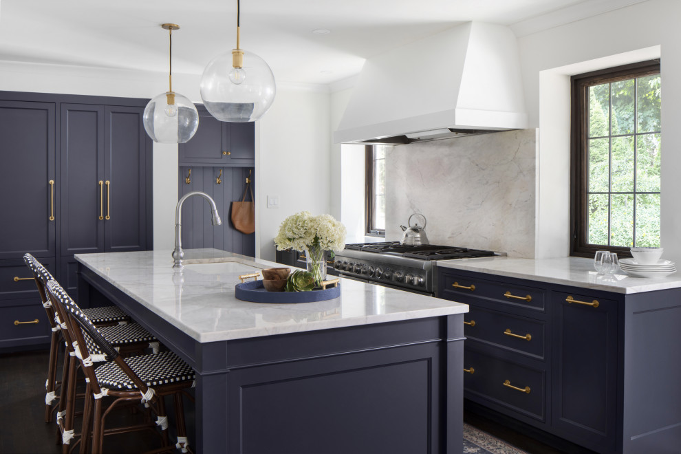 Foto på ett stort vintage vit kök och matrum, med en undermonterad diskho, skåp i shakerstil, blå skåp, bänkskiva i kvartsit, vitt stänkskydd, stänkskydd i sten, integrerade vitvaror, mörkt trägolv, en köksö och brunt golv