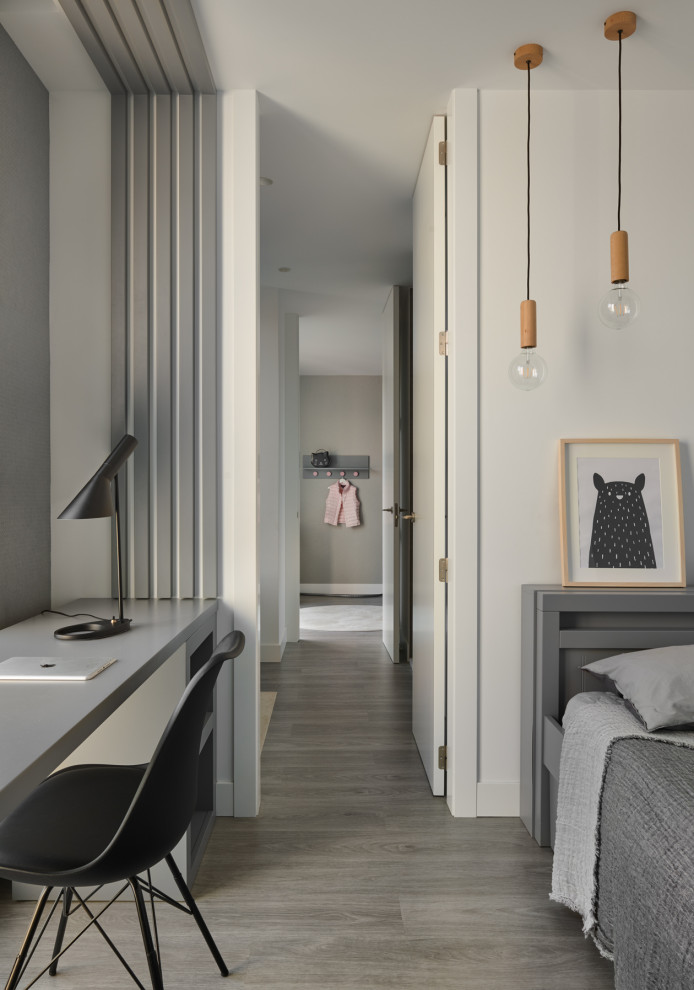 Bild på ett industriellt könsneutralt tonårsrum kombinerat med sovrum, med vita väggar, ljust trägolv och brunt golv