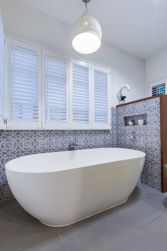 Photo of a transitional bathroom in Brisbane with flat-panel cabinets, white cabinets, gray tile, ceramic tile, white walls, ceramic floors, a vessel sink, marble benchtops and beige floor.