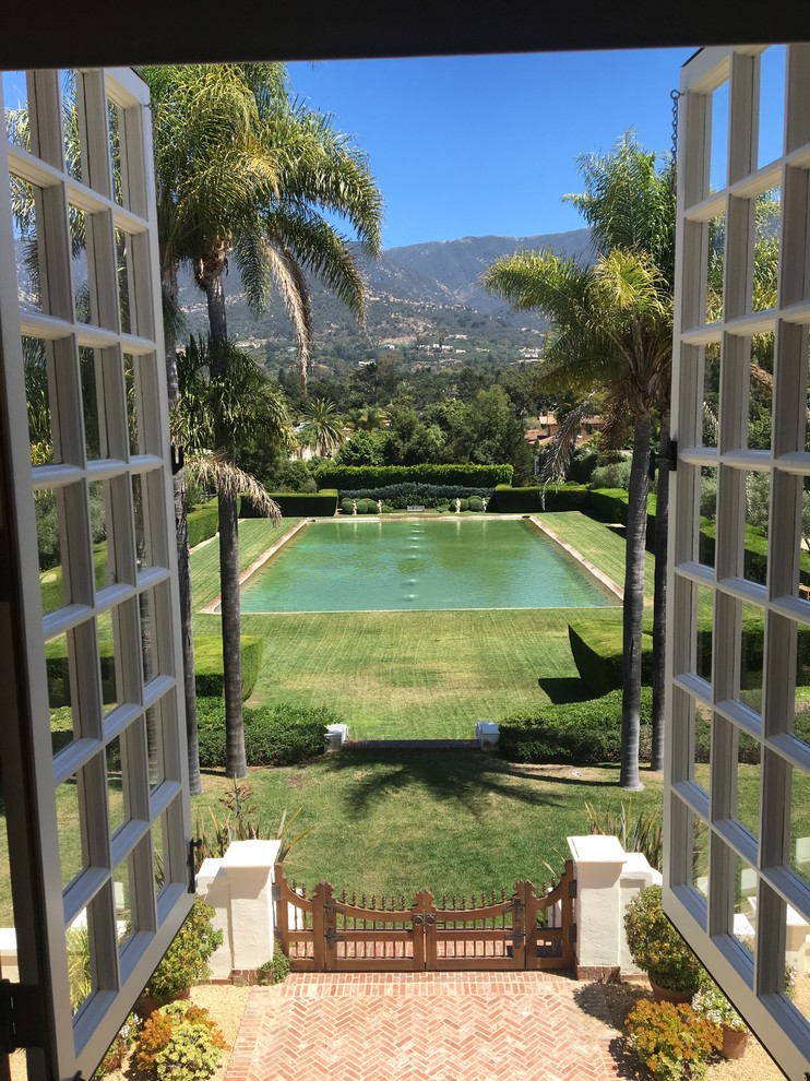 Photo of an expansive midcentury courtyard full sun formal garden for summer in Santa Barbara with a container garden and brick pavers.