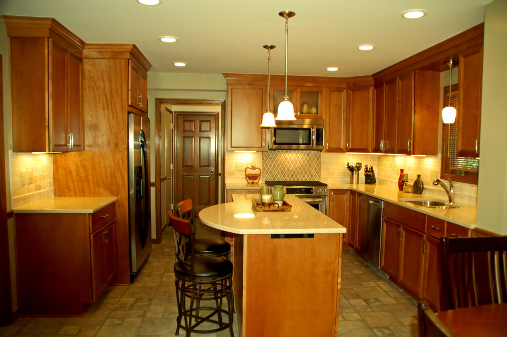 Inspiration for a mid-sized transitional l-shaped ceramic tile eat-in kitchen remodel in Columbus with an undermount sink, flat-panel cabinets, medium tone wood cabinets, quartz countertops, beige backsplash, stone tile backsplash, stainless steel appliances and an island