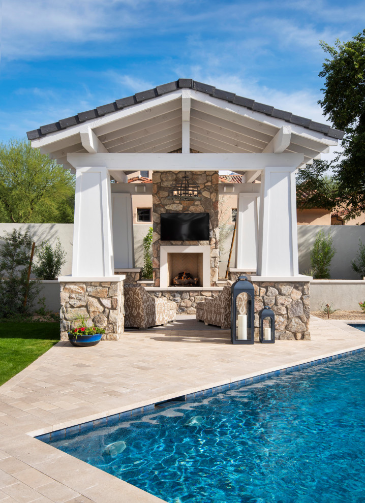 Large transitional backyard stone and custom-shaped pool house photo in Phoenix