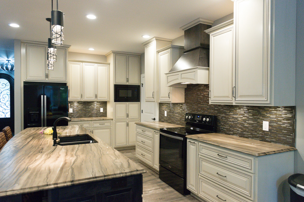 Eat-in kitchen - large transitional l-shaped ceramic tile eat-in kitchen idea in Chicago with an undermount sink, raised-panel cabinets, dark wood cabinets, marble countertops, brown backsplash, glass tile backsplash, black appliances and an island
