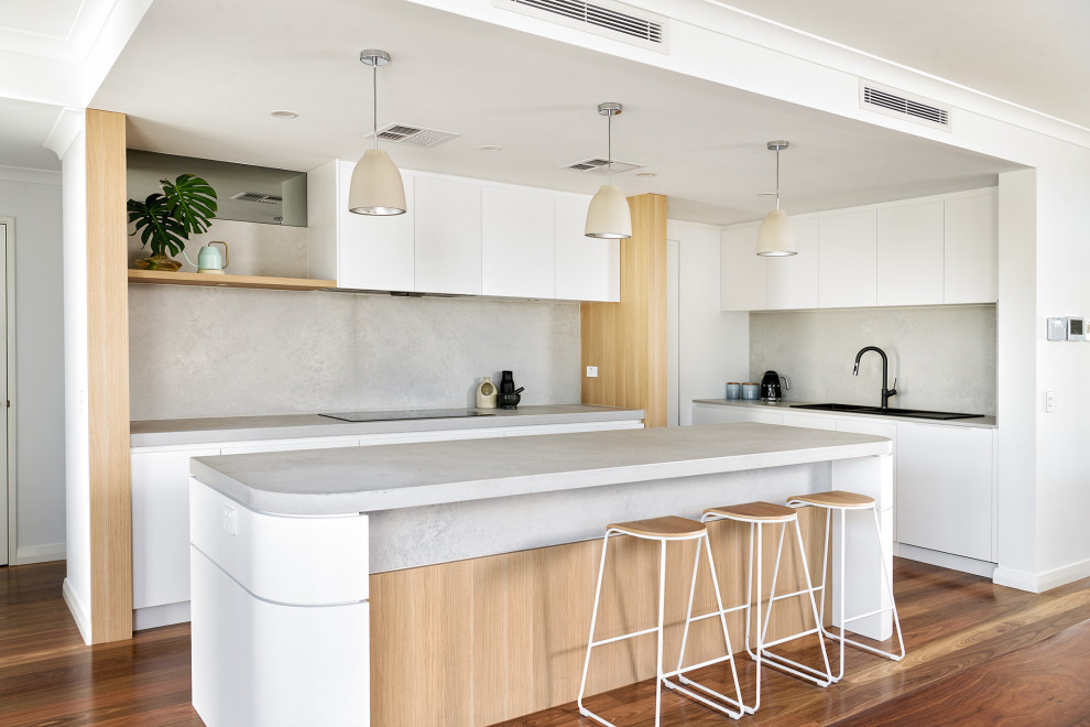 This is an example of a large scandinavian l-shaped eat-in kitchen in Perth with a double-bowl sink, flat-panel cabinets, white cabinets, quartz benchtops, grey splashback, engineered quartz splashback, medium hardwood floors, with island, brown floor and grey benchtop.