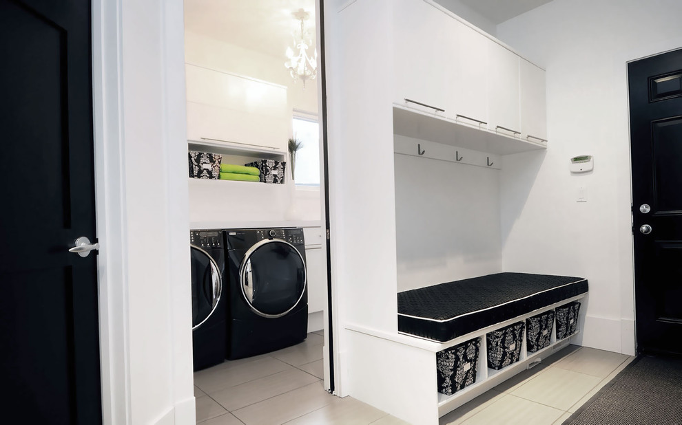 Contemporary laundry room in Other with flat-panel cabinets, white cabinets and a side-by-side washer and dryer.