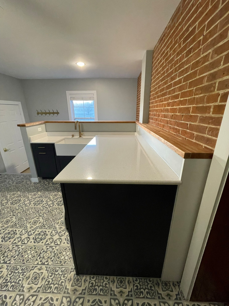 Cottage vinyl floor and multicolored floor laundry room photo in St Louis with a farmhouse sink, shaker cabinets, blue cabinets, quartz countertops, white backsplash, quartz backsplash, blue walls, a concealed washer/dryer and white countertops