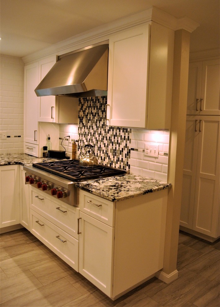 Transitional kitchen photo in Boston with an undermount sink, shaker cabinets, granite countertops, subway tile backsplash, stainless steel appliances and an island