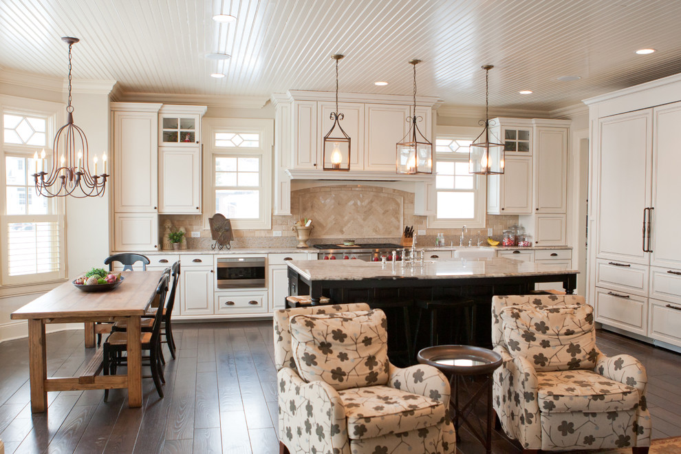 Large transitional l-shaped dark wood floor eat-in kitchen photo in Chicago with raised-panel cabinets, white cabinets, granite countertops, beige backsplash, stainless steel appliances, an island, a farmhouse sink and porcelain backsplash
