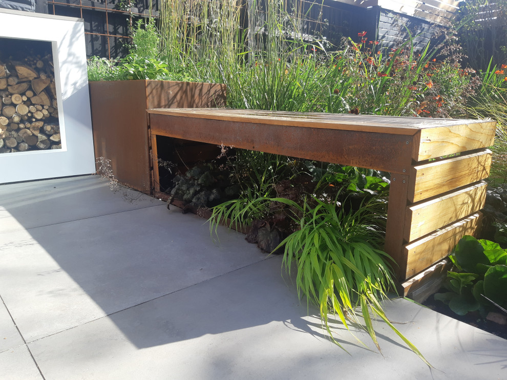 Idee per una piccola aiuola minimal esposta in pieno sole dietro casa in estate con pavimentazioni in cemento