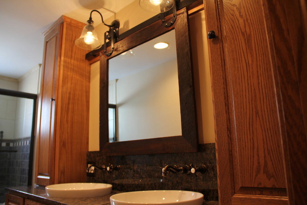Transitional brown tile and porcelain tile porcelain tile tub/shower combo photo in Columbus with a vessel sink, an undermount tub, a two-piece toilet, raised-panel cabinets, medium tone wood cabinets, granite countertops and beige walls