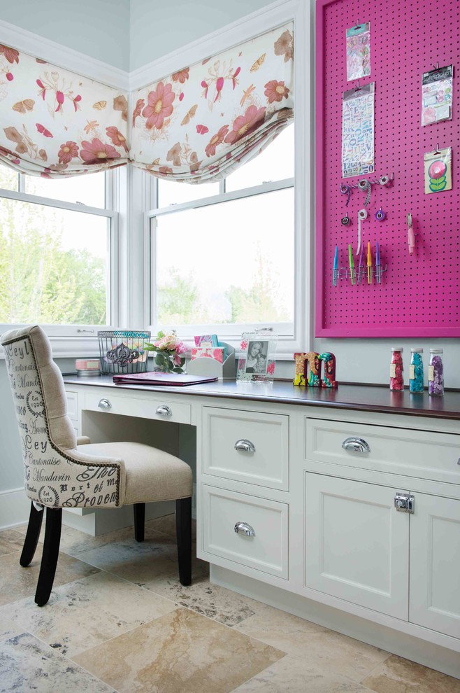 This is an example of a transitional craft room in Kansas City with grey walls, a built-in desk and beige floor.