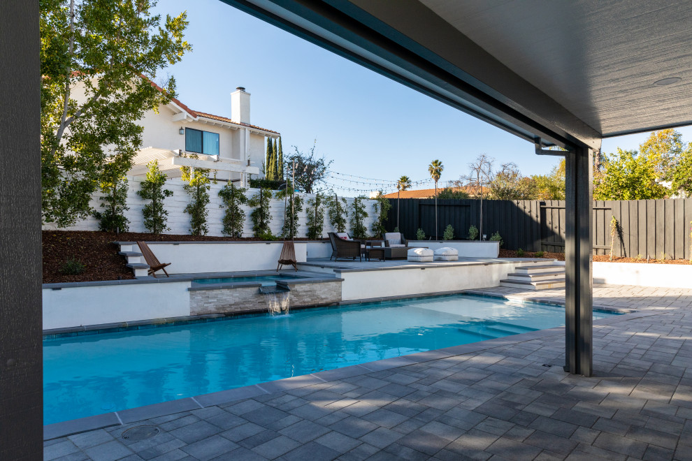 Esempio di una grande piscina monocorsia minimalista rettangolare dietro casa con paesaggistica bordo piscina e pavimentazioni in cemento