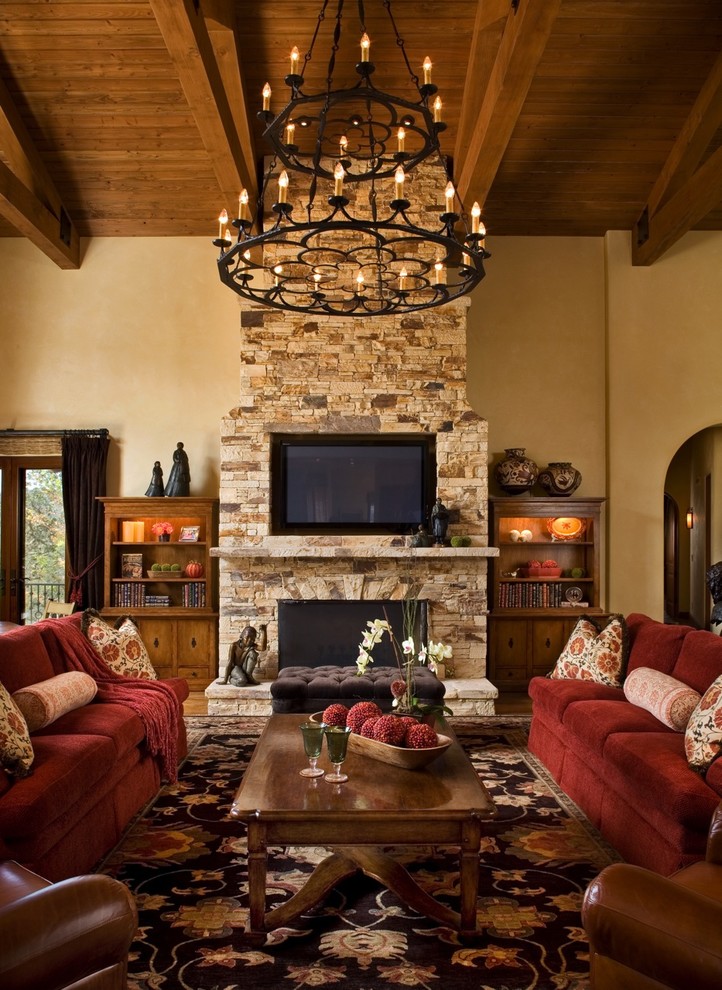 This is an example of a country living room in Other with a stone fireplace surround.