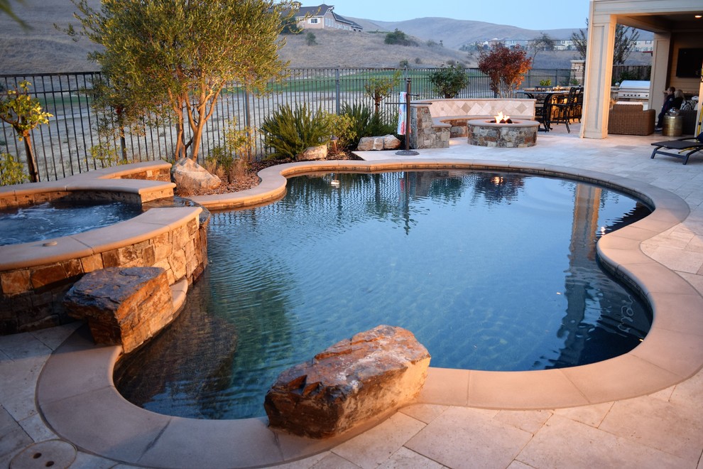 Diseño de piscina mediterránea pequeña en patio trasero con adoquines de piedra natural