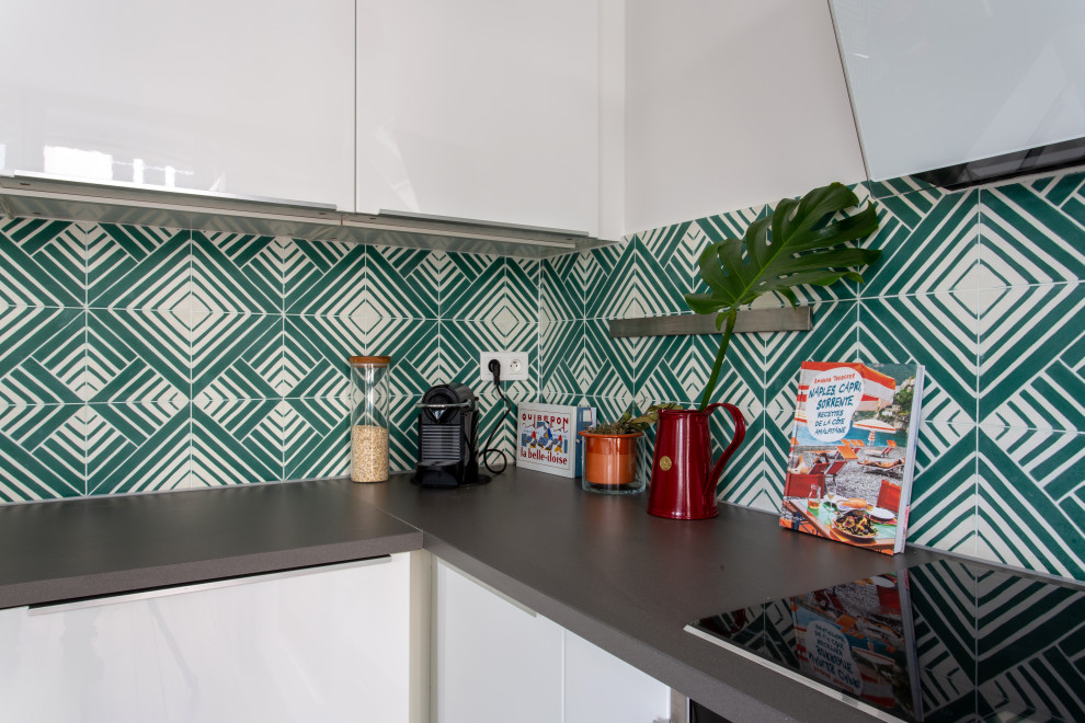 Inspiration for a mid-sized midcentury u-shaped separate kitchen in Paris with an undermount sink, beaded inset cabinets, white cabinets, quartzite benchtops, green splashback, cement tile splashback, black appliances, medium hardwood floors, no island and grey benchtop.