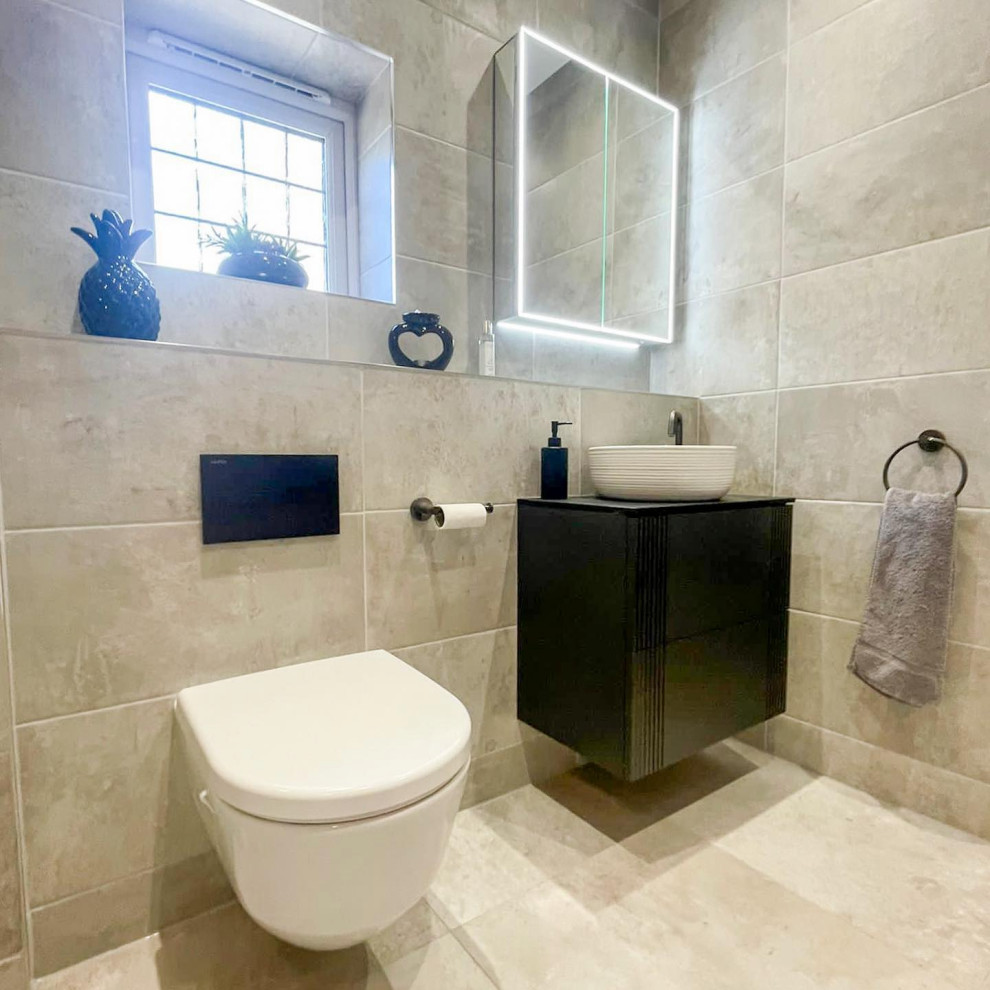 Mid-sized modern powder room in West Midlands with flat-panel cabinets, black cabinets, a wall-mount toilet, beige tile, ceramic tile, beige walls, ceramic floors, an integrated sink, laminate benchtops, beige floor, beige benchtops and a floating vanity.