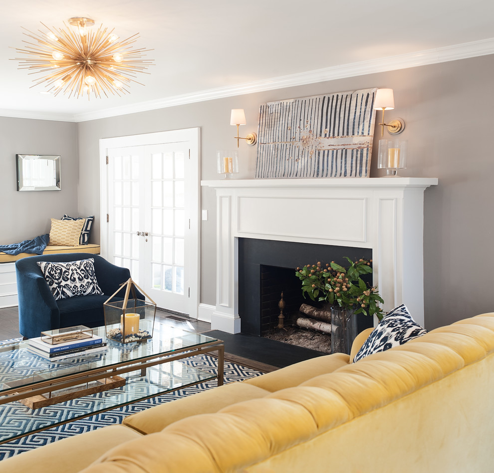 Example of a mid-sized trendy enclosed dark wood floor living room design in New York with gray walls, a standard fireplace, a stone fireplace and no tv