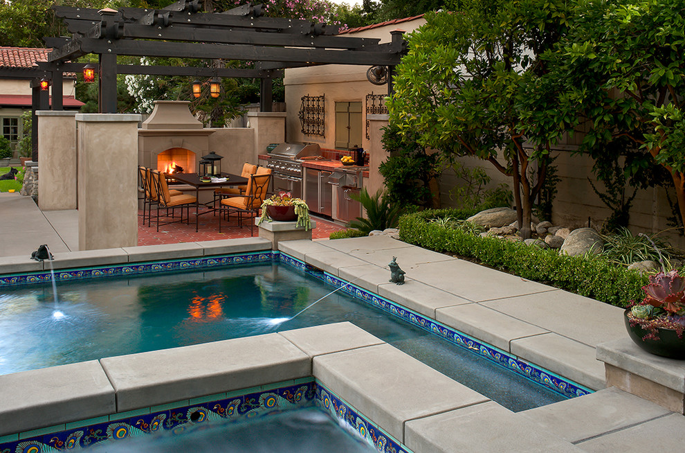 Design ideas for a mid-sized mediterranean backyard rectangular lap pool in Los Angeles with a water feature and tile.