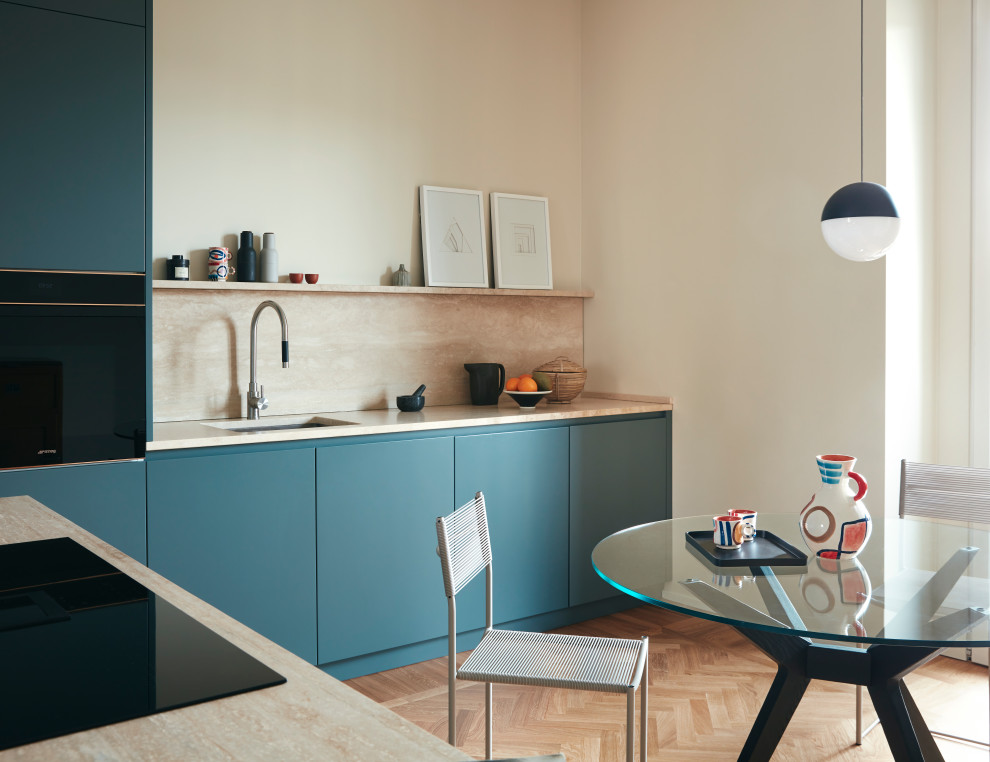 Ispirazione per una cucina minimal chiusa e di medie dimensioni con ante blu, top in marmo, paraspruzzi in marmo, elettrodomestici neri e parquet chiaro