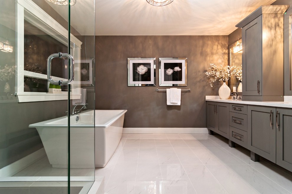 This is an example of a contemporary bathroom in Vancouver with shaker cabinets, grey cabinets, a freestanding tub, white tile, white floor and white benchtops.