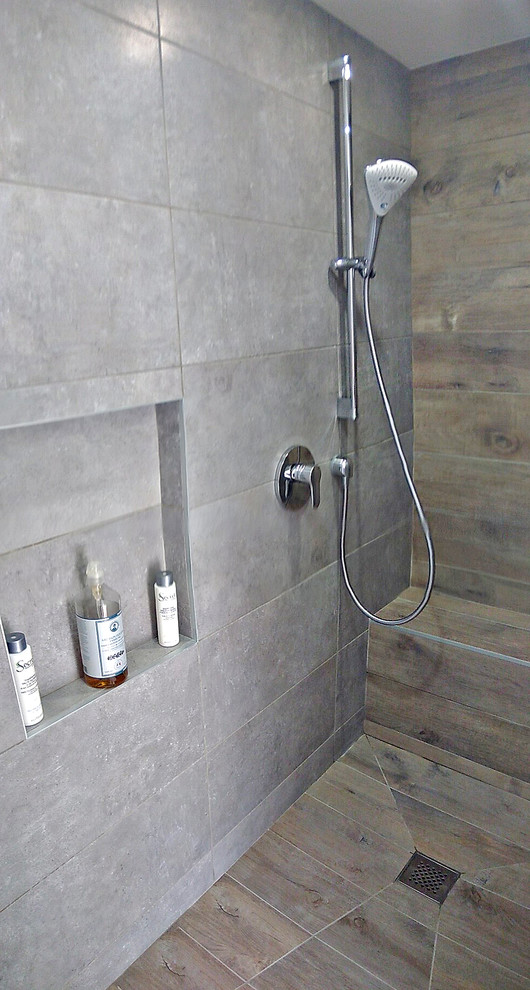 Idéer för att renovera ett mellanstort funkis vit vitt badrum med dusch, med luckor med profilerade fronter, grå skåp, en kantlös dusch, grå kakel, keramikplattor, grå väggar, klinkergolv i keramik, ett konsol handfat, bänkskiva i akrylsten, brunt golv och med dusch som är öppen