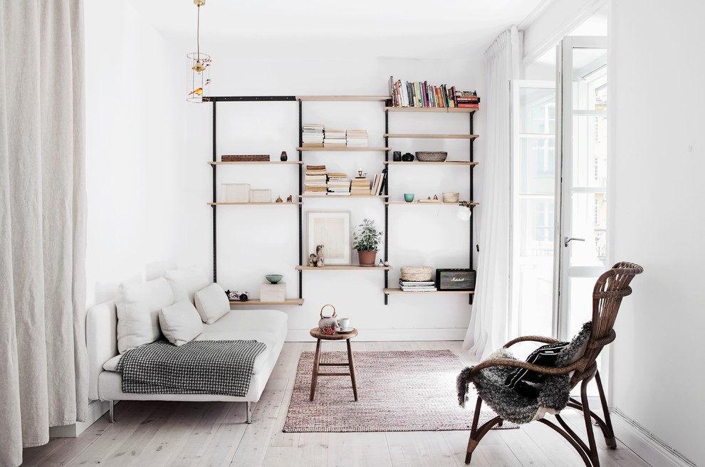 This is an example of a large scandinavian formal open concept living room in Stockholm with white walls, light hardwood floors, no fireplace and no tv.