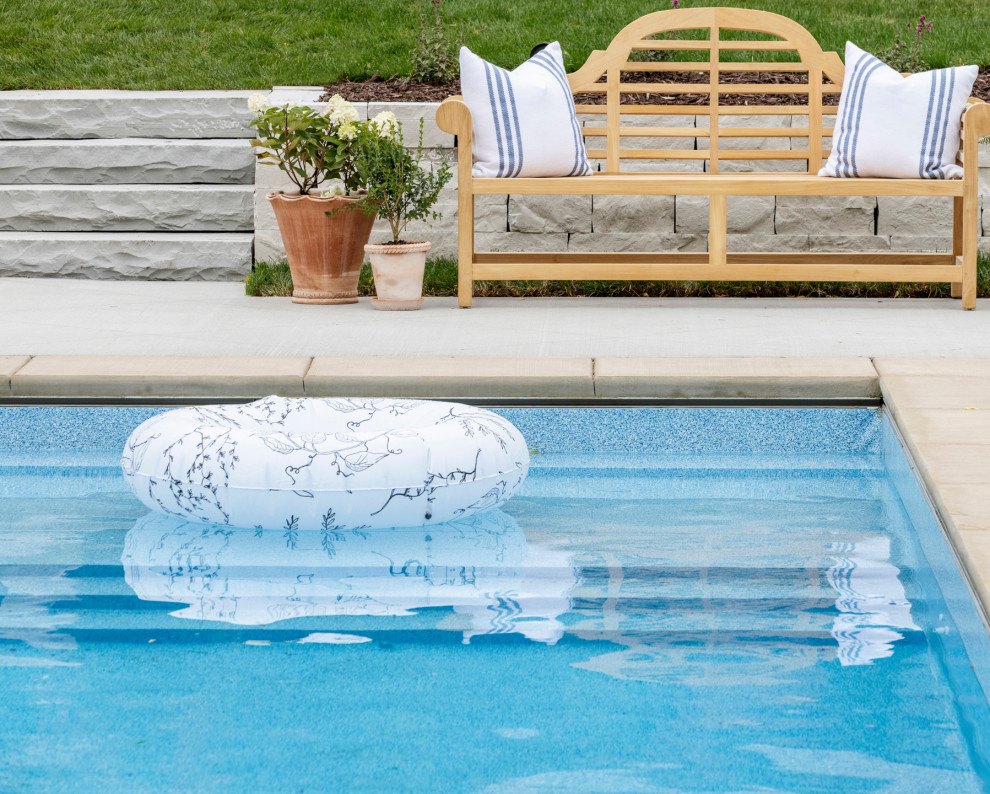 Klassischer Pool hinter dem Haus in rechteckiger Form mit Pool-Gartenbau und Natursteinplatten in Minneapolis