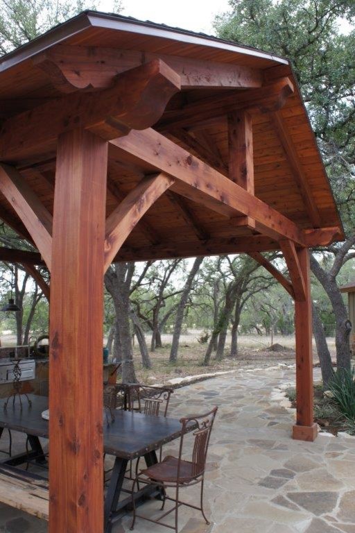 This is an example of a large arts and crafts backyard patio in Austin with an outdoor kitchen, natural stone pavers and a gazebo/cabana.