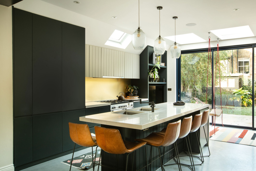 Design ideas for a medium sized contemporary single-wall kitchen/diner in London with flat-panel cabinets, metallic splashback, integrated appliances, concrete flooring, an island, white worktops, a built-in sink and grey floors.