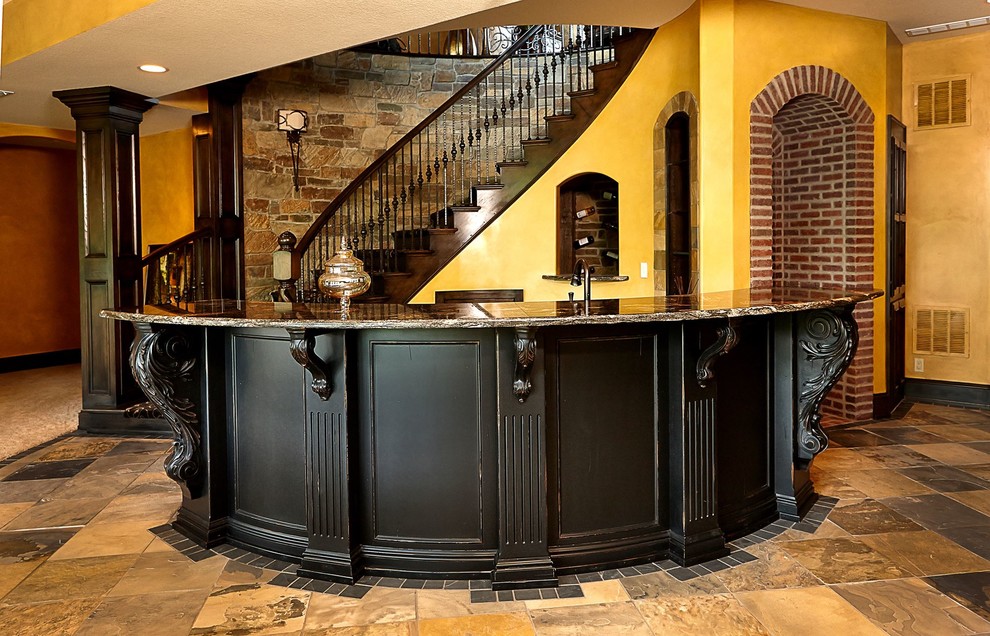 This is an example of a large traditional galley wet bar in Kansas City with slate floors, black cabinets, granite benchtops, black splashback and multi-coloured floor.