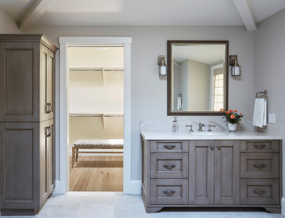 This is an example of a mid-sized country master bathroom in San Francisco with shaker cabinets, medium wood cabinets, a freestanding tub, a two-piece toilet, white walls, porcelain floors, an undermount sink, engineered quartz benchtops, grey floor and white benchtops.
