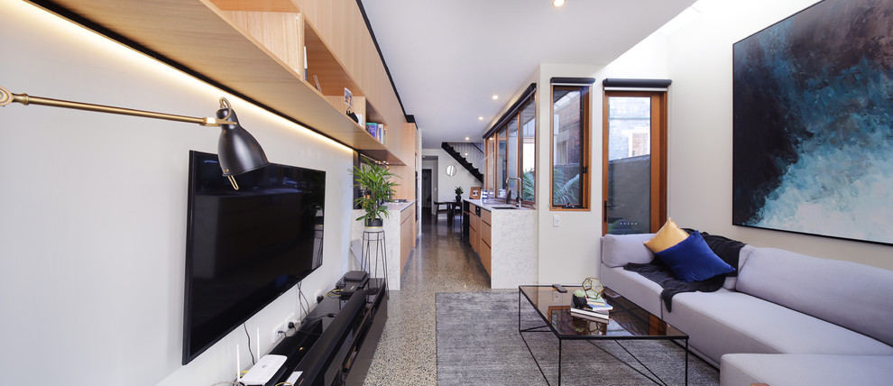 Small contemporary formal open concept living room in Melbourne with white walls, concrete floors, a wall-mounted tv and multi-coloured floor.