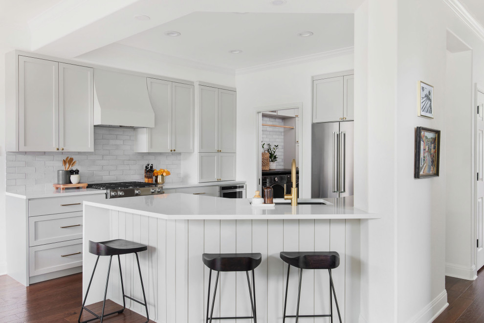 Mid-sized transitional medium tone wood floor and brown floor kitchen photo in Austin with an undermount sink, shaker cabinets, gray cabinets, quartz countertops, white backsplash, brick backsplash and white countertops