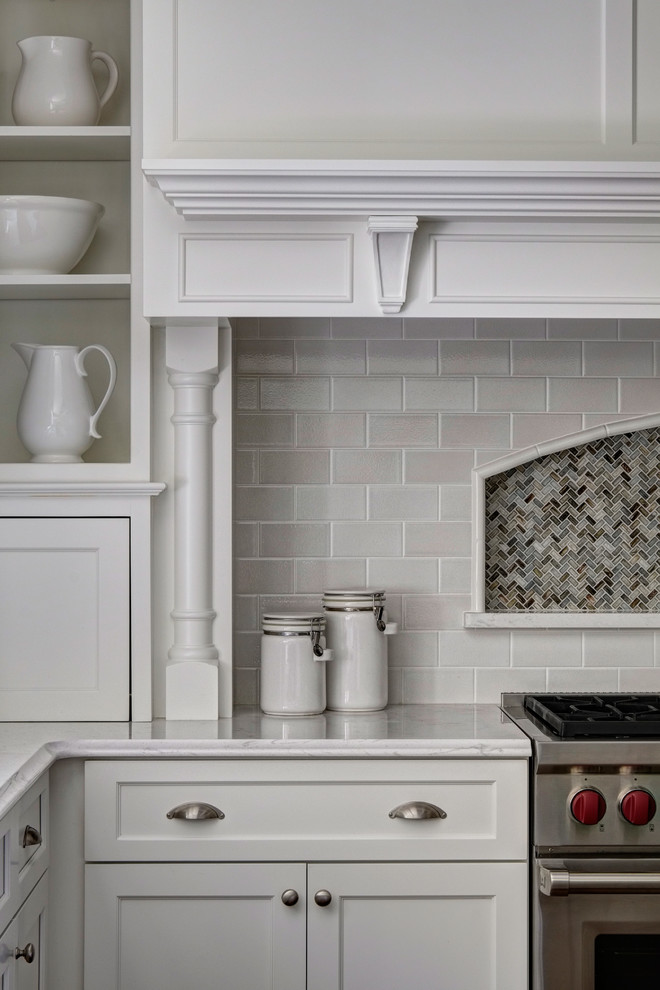 Klassisk inredning av ett kök, med en rustik diskho, skåp i shakerstil, vita skåp, bänkskiva i koppar, stänkskydd i keramik, rostfria vitvaror, mörkt trägolv och en köksö