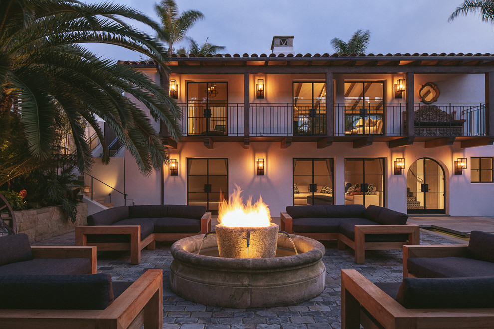 Mediterranean patio in Santa Barbara with a fire feature and no cover.