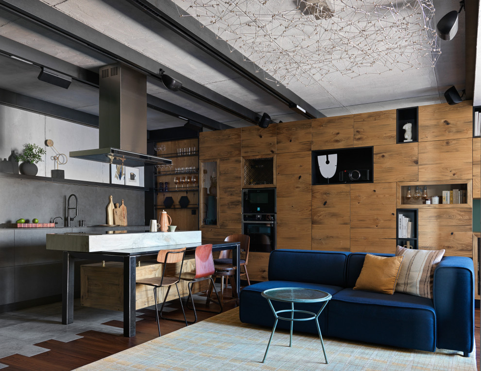 Aménagement d'un salon industriel de taille moyenne et ouvert avec un sol en bois brun, un téléviseur encastré, un sol marron, poutres apparentes et un mur vert.
